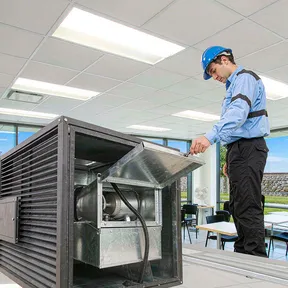 Technician inspecting Deiiang backdraft dampers in a commercial building exhaust system Technician inspecting Deiiang backdraft dampers in a commercial building exhaust system