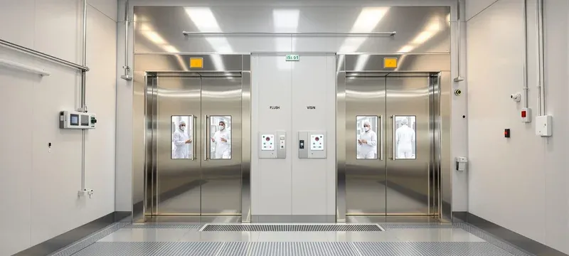 Interlocked automatic sliding doors at a cleanroom personnel access point after retrofit