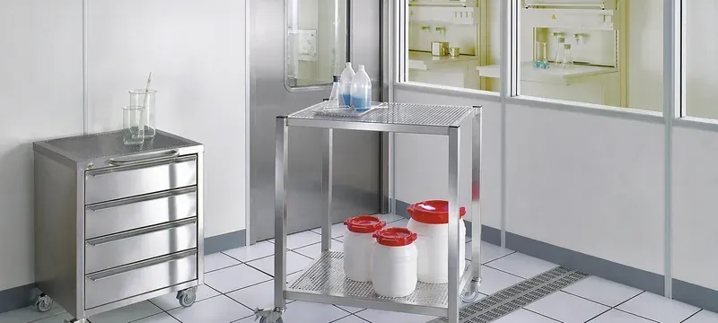 Stainless steel trolley in a cleanroom material corridor in front of a closed door leaf